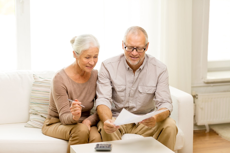 Senior couple with going over their utility bill with a calculator at home. How Can I Save Money on My Heating Bill This Winter?