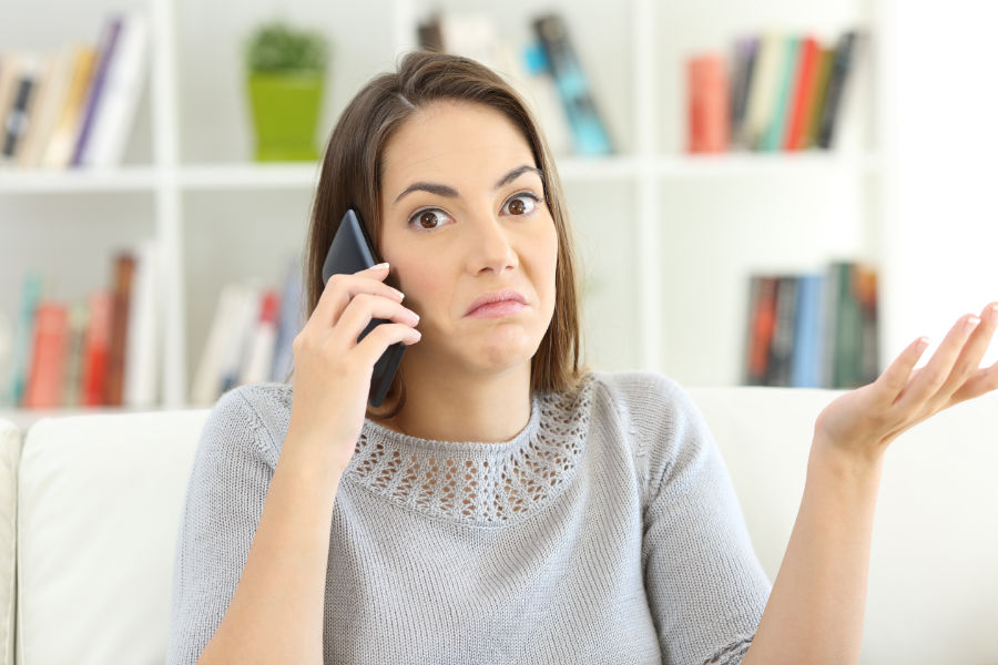 Woman on phone looking confused. What You Need to Know for an HVAC Emergency